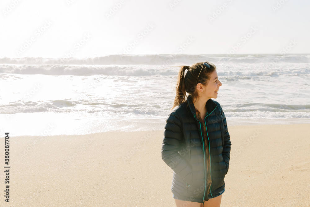 Woman stands on the beach in the sunshine Woman stands on the beach in the sunshine