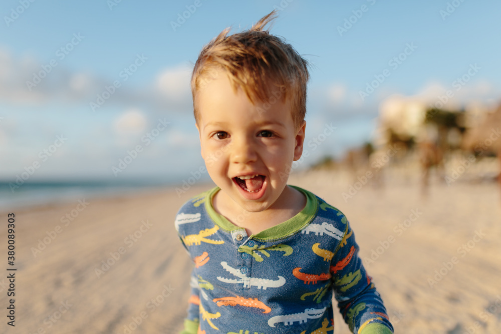 Cute young boy running on a beach Cute young boy running on a beach