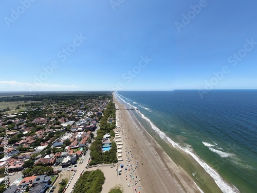 Foto desde dron del mar azul y la playa, en un pueblo de veraneo.  © Carlos M