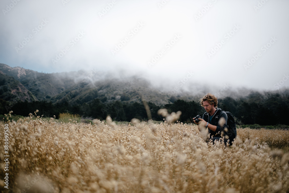 Photographer taking photos in a field in Big Sur,California during summer. Photographer taking photos in a field in Big Sur,California during summer.