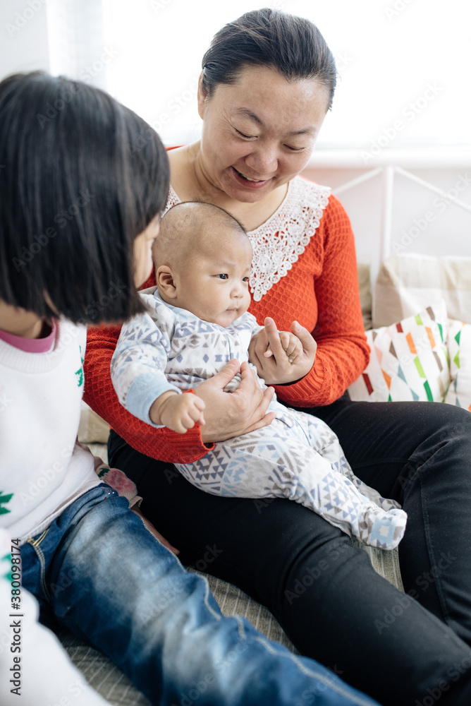 Mother holding newborn bay with his big sister Mother holding newborn bay with his big sister