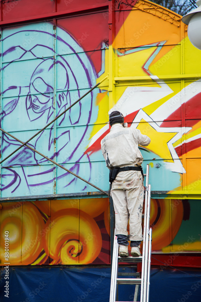 A person standing and painting graffiti A person standing and painting graffiti