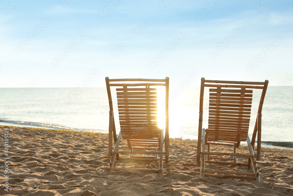 Wooden deck chairs on sandy beach. Summer vacation - obrazy, fototapety, plakaty 