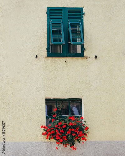 Windows with binds typical of Italian region Liguria decorated with flower pot photo