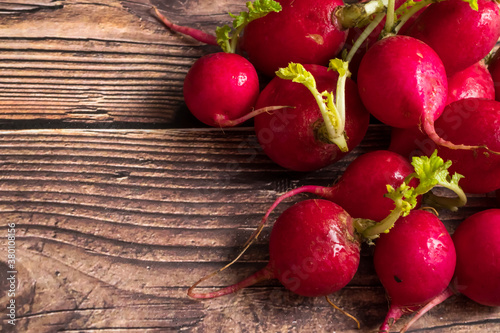 Top view of red ripe radishes on wooden background