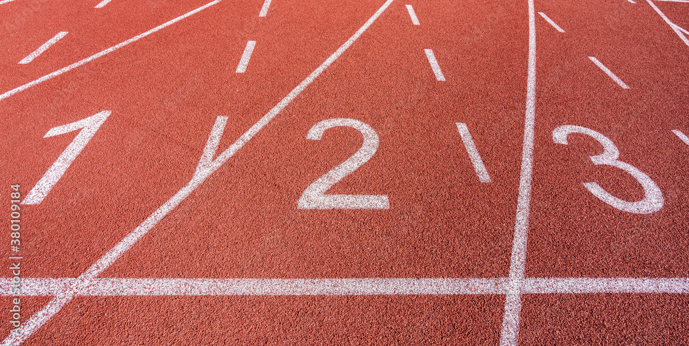 White painted lines and numbers on a running track in a athleticism and sports field. 