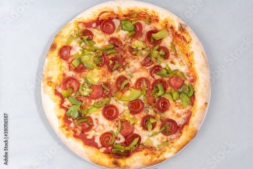 Overhead view of healthy sized pepperoni and green pepper pizza with thick crust to complete a delicious meal to eat