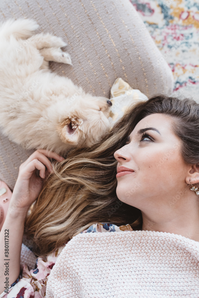 A young woman laying in bed with her dog A young woman laying in bed with her dog
