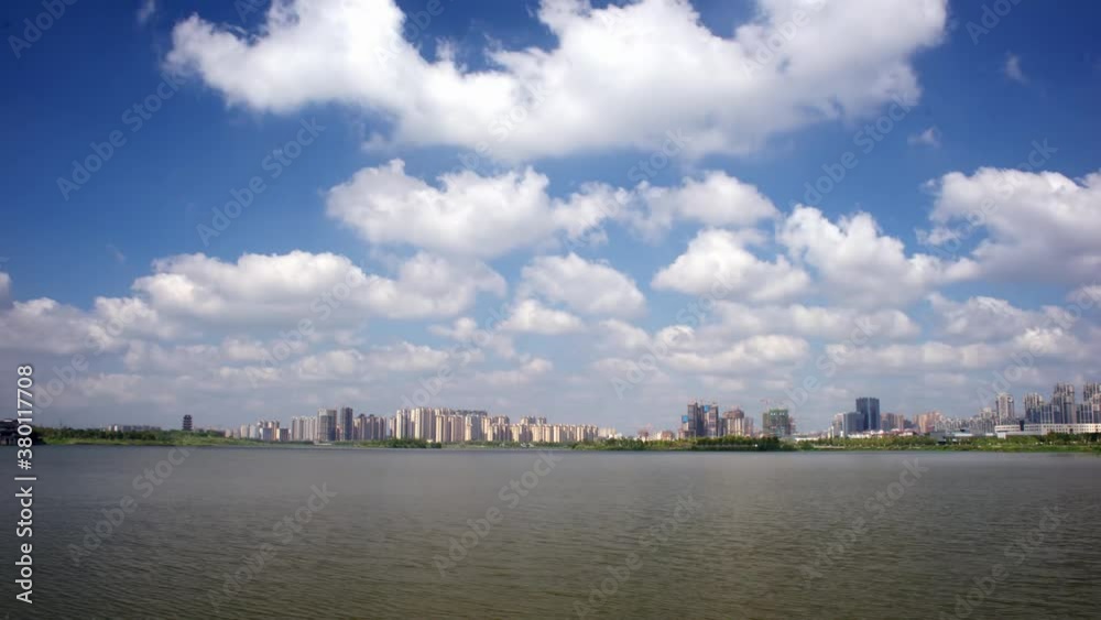 Lake view in city of China, cotton clouds flowing in the blue sky, time-lapse Lake view in city of China, cotton clouds flowing in the blue sky, time-lapse