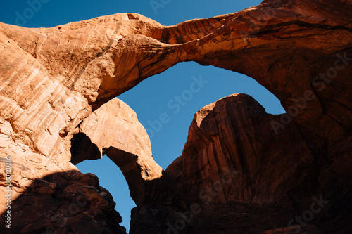 Red rock arches form shapes in the blue sky in Arches National Park