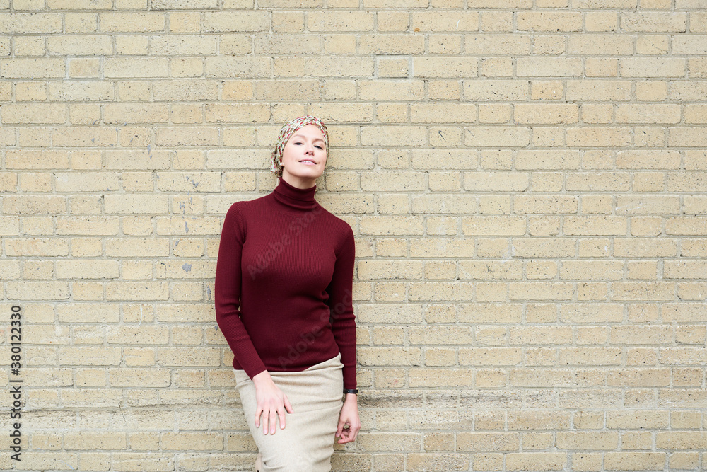 Beautiful woman smiling at camera over beige brick wall. Beautiful woman smiling at camera over beige brick wall.