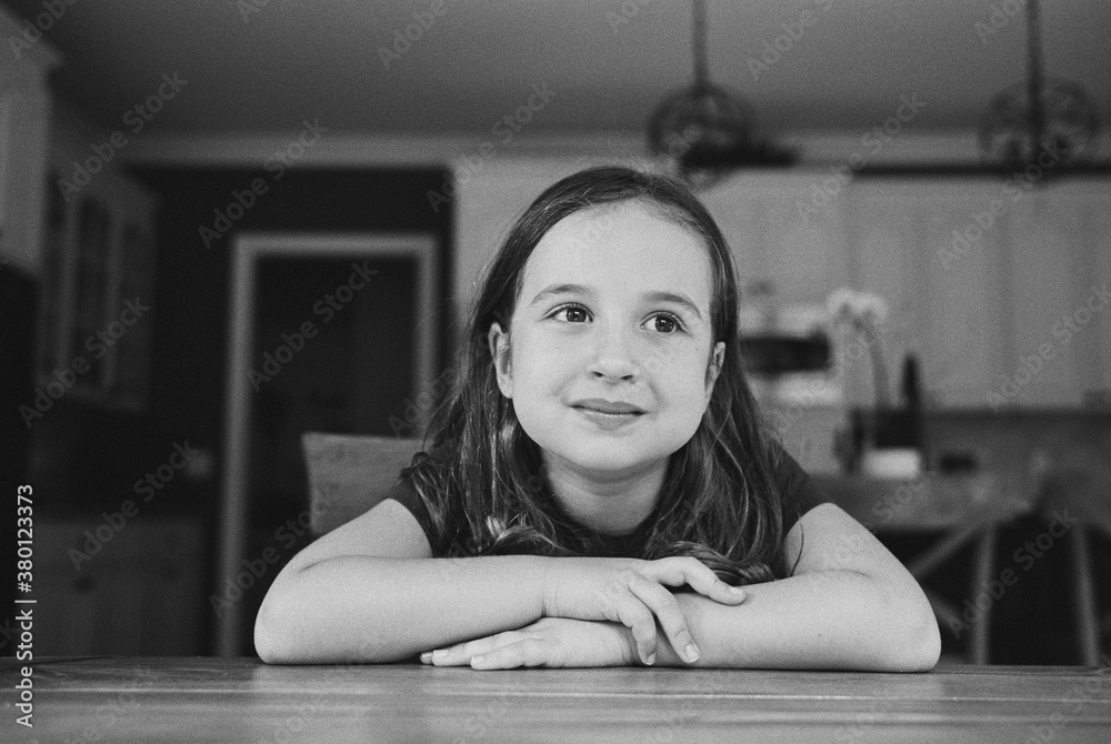 Beautiful young girl sitting at a kitchen table Beautiful young girl sitting at a kitchen table