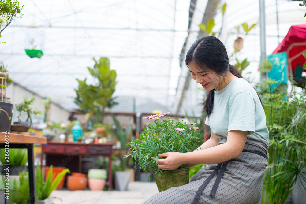 One young female florist working in the shop