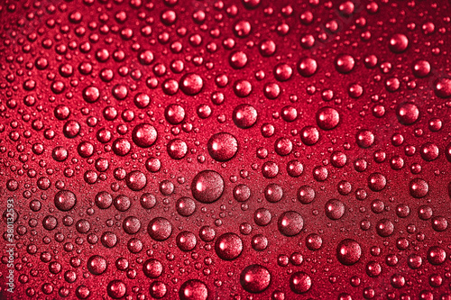Red texture of water drops on the metal surface. Close-up macrophotography of wet droplets.
