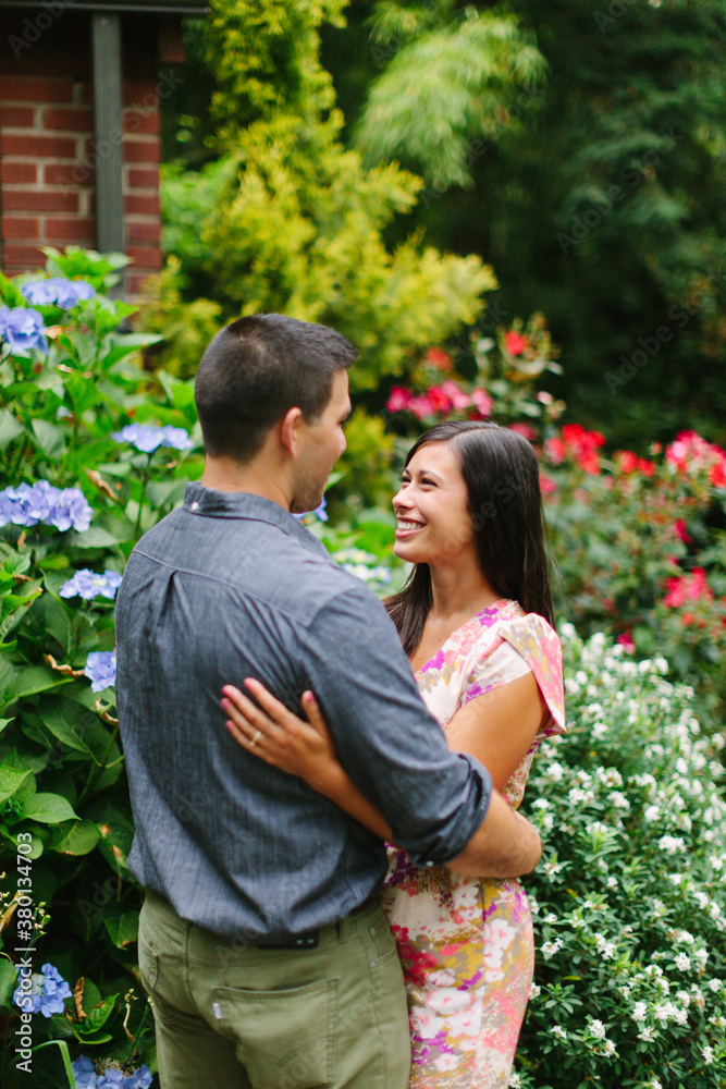 Couple Smiling and Embracing in Flower Garden Couple Smiling and Embracing in Flower Garden