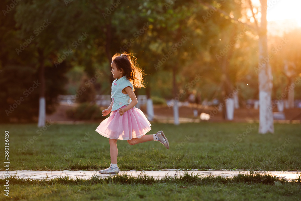 Adorable girl running in a park Adorable girl running in a park