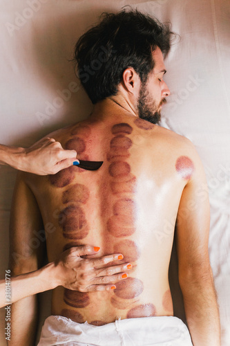 Therapist giving massage to a man at alternative healing center in Thailand