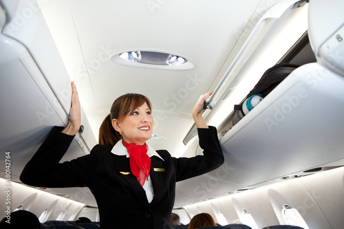 Airplane: Stewardess Closes Compartments Before Take Off photo