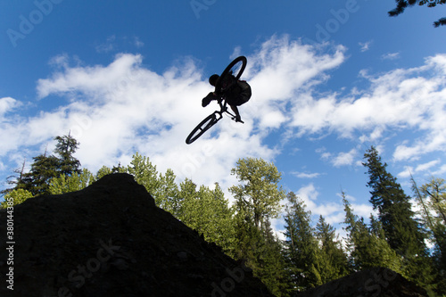 Bike jump silhouette. Tailwhip on dirt jumps photo