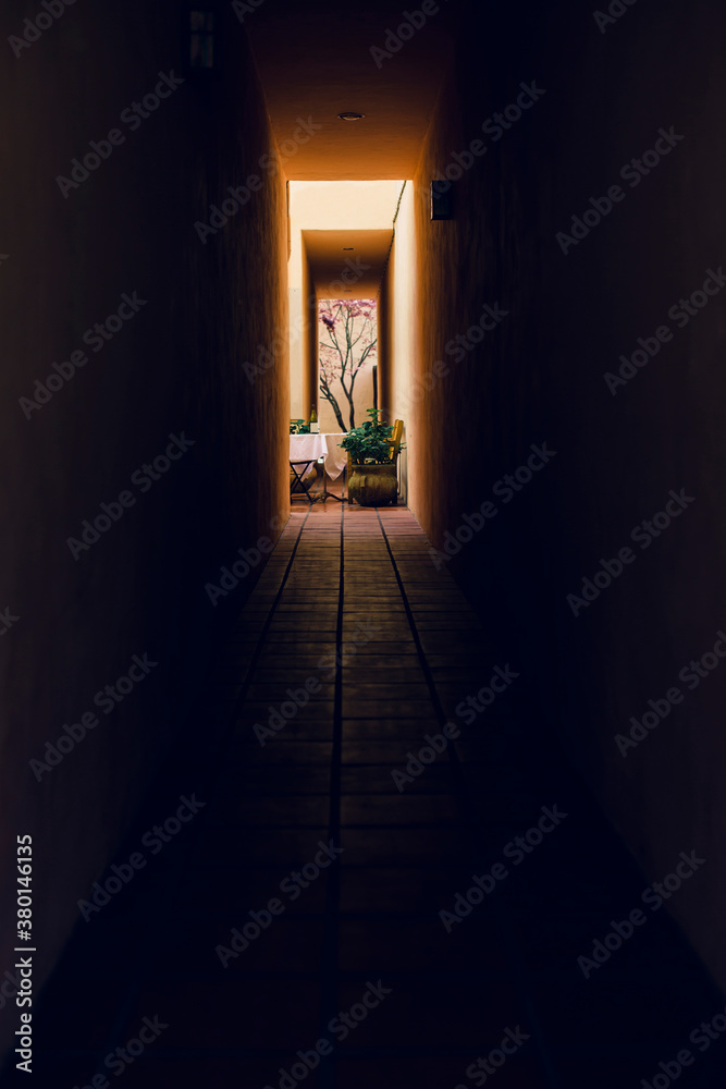 A dark passageway reveals a charming courtyard dining area. A dark passageway reveals a charming courtyard dining area.