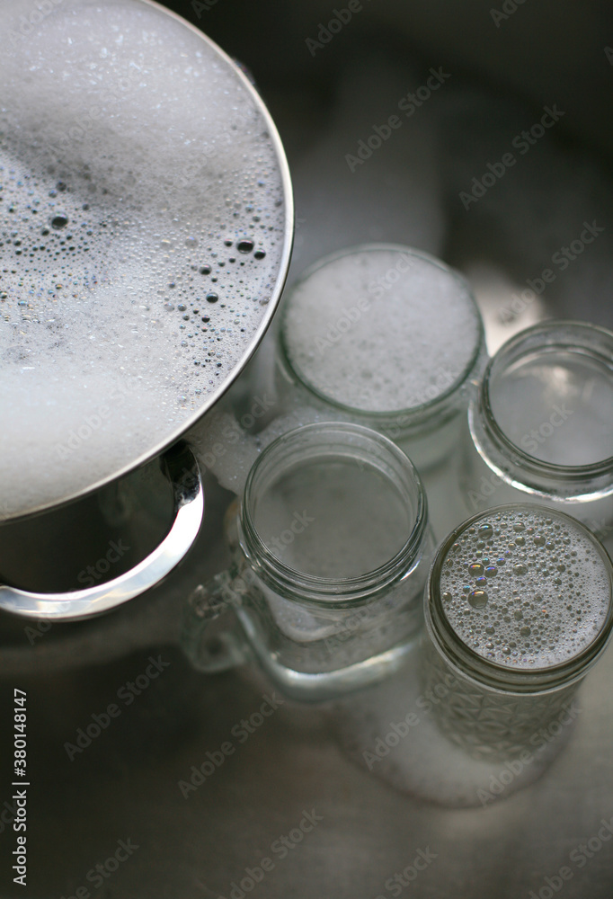 A Pot and Glasses In A Sink A Pot and Glasses In A Sink