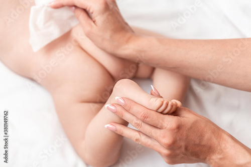 A newborn baby gets a diaper change concept of cleanliness and carethe mother wipes the baby with a baby wipe. massage for baby. Health care concept