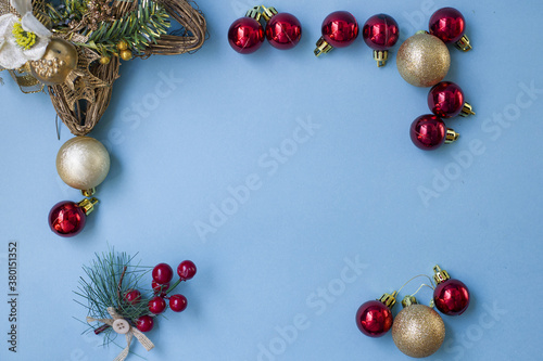 Christmas composition. Frame from branches of a Christmas tree, red and gold decorations and red berries on a white background. Flat lounger, top view, copy space