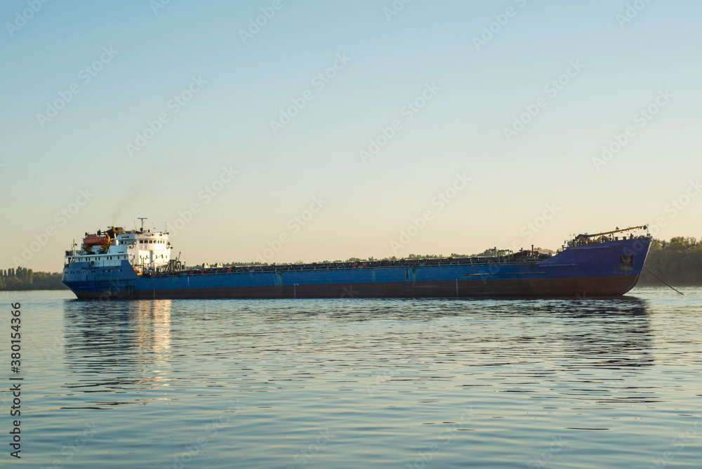 Large cargo ship sailing in still water. Cargo ship on the river