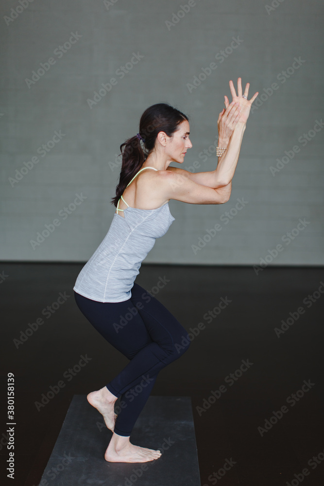 A beautiful woman practicing yoga in a studio