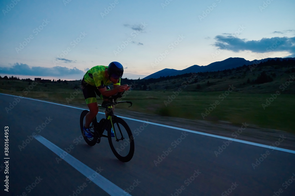 triathlon athlete riding bike at night triathlon athlete riding bike at night
