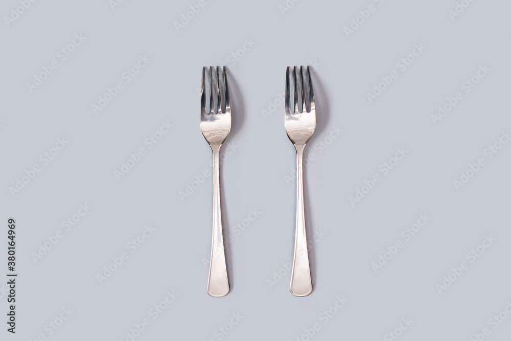 two forks in the center of the frame on a gray background two forks in the center of the frame on a gray background