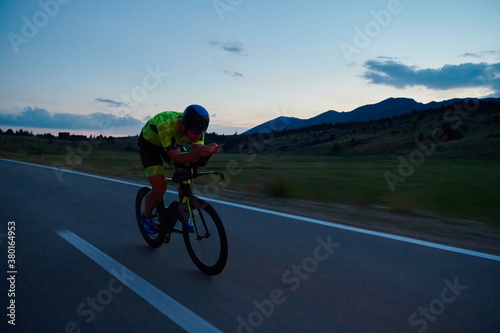 Fototapeta Naklejka Na Ścianę i Meble -  triathlon athlete riding bike at night