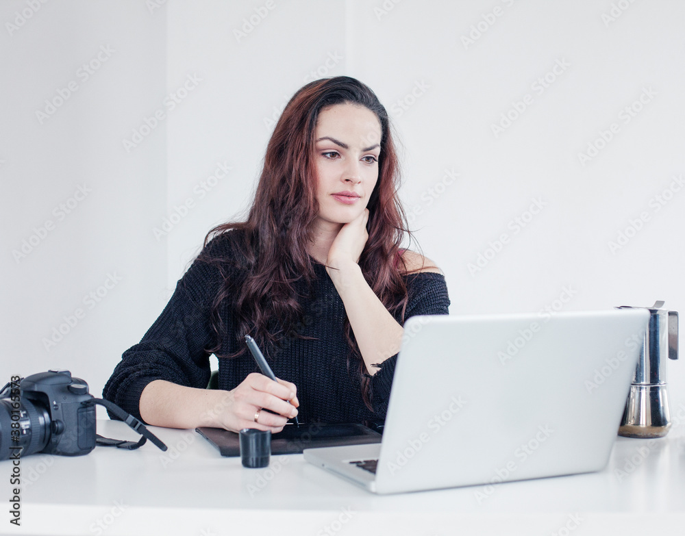 Photographer editing and retouching at her desk Photographer editing and retouching at her desk