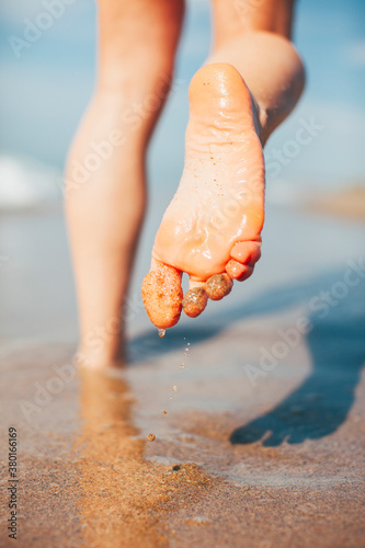 Barefoot running on the beach. Sporty woman on the beach. photo