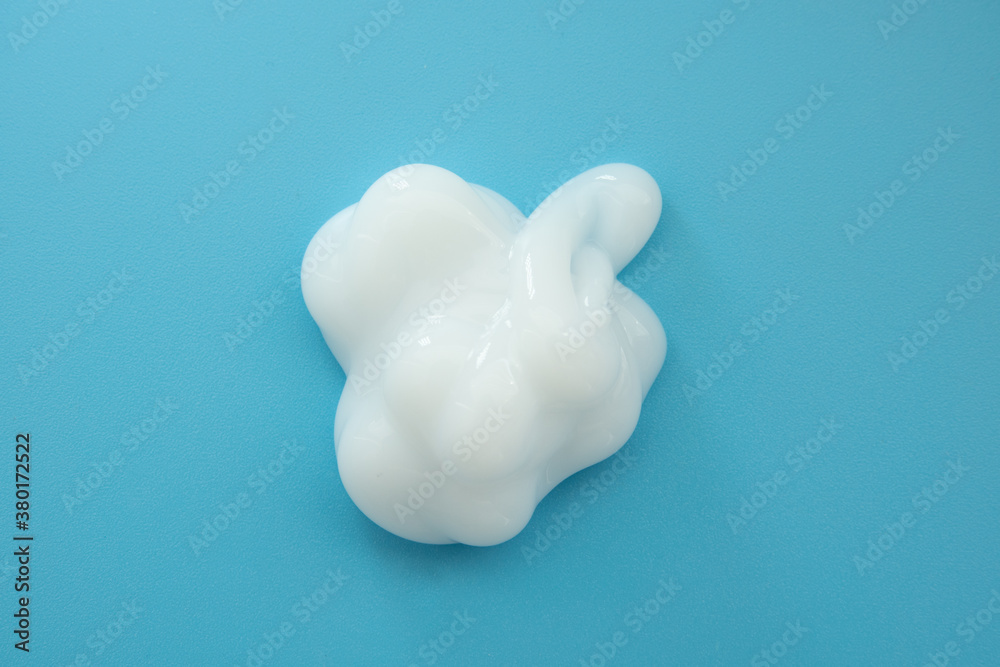 White cosmetic cream lotion moisturizer strokes on pastel blue. Hygiene, skincare product creamy texture. Beauty face creme smear smudge swatch on color background White cosmetic cream lotion moisturizer strokes on pastel blue. Hygiene, skincare product creamy texture. Beauty face creme smear smudge swatch on color background