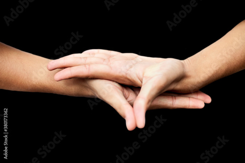 Close up shot of male hands demonstrating Buddha Mudra over black background.