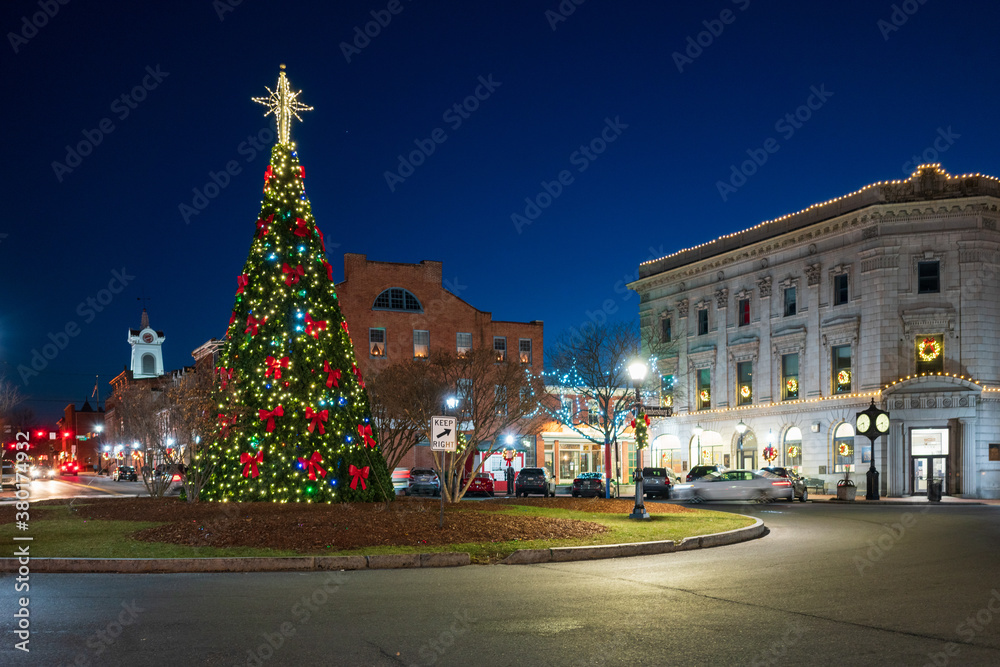 Historic town square with holiday tree lit up at night at Christmas