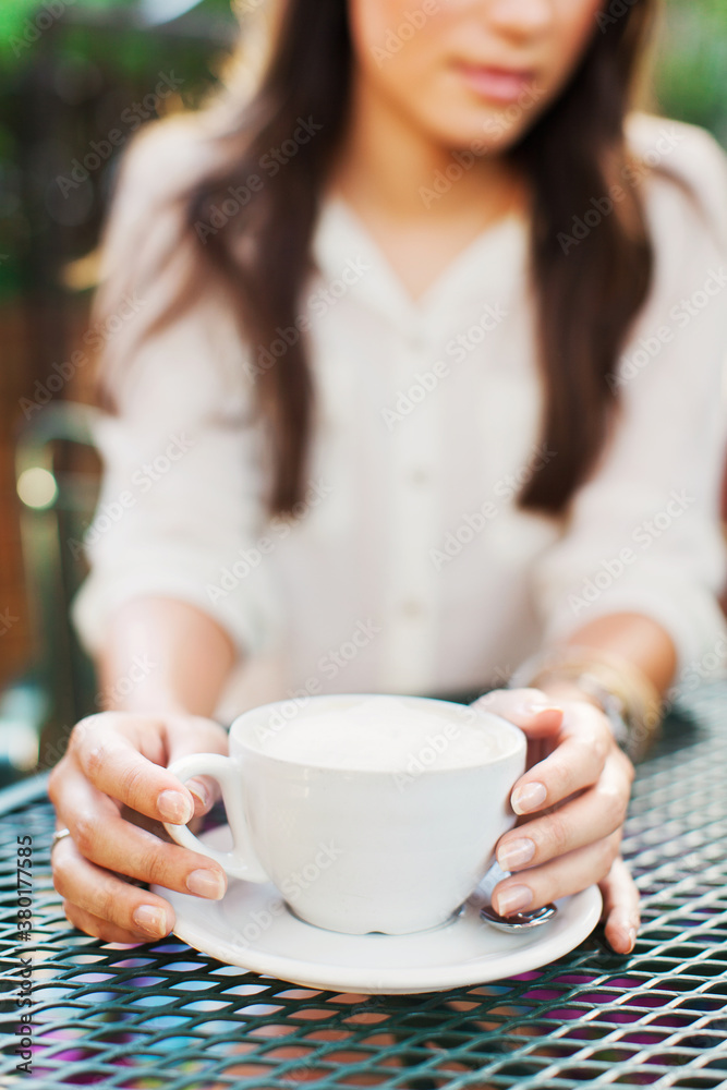 Girl holding a cup of cappuccino Girl holding a cup of cappuccino