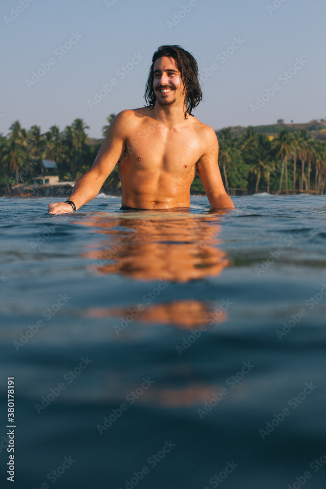 Surfer sitting on his surfboard Surfer sitting on his surfboard