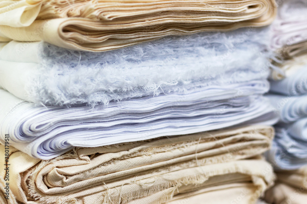 The fabric of pastel shades is neatly folded to stack, front view The fabric of pastel shades is neatly folded to stack, front view