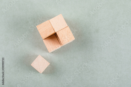 Conceptual of business with wooden cube with one block near on sage color background flat lay. space for text horizontal image