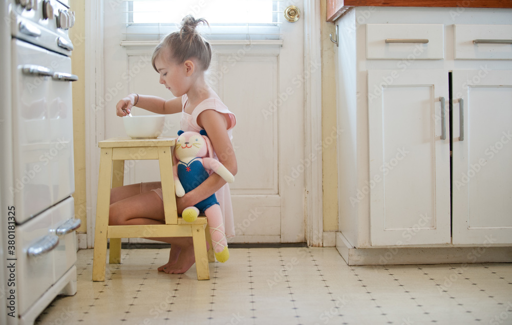 little girl dressed as ballerina with toy in kitchen little girl dressed as ballerina with toy in kitchen