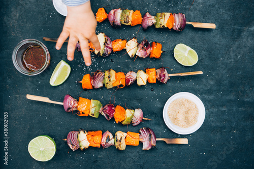 Food: Barbecue skewers with onions, sweet potato and avocado with chili strings and lime, caribbean veggie style photo