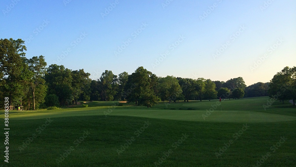 Sun setting over a golf course fairway and green Sun setting over a golf course fairway and green