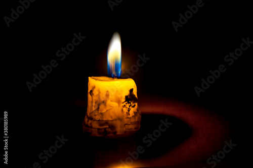 Shot of a single isolated candle burning itself and giving light to its surrounding.