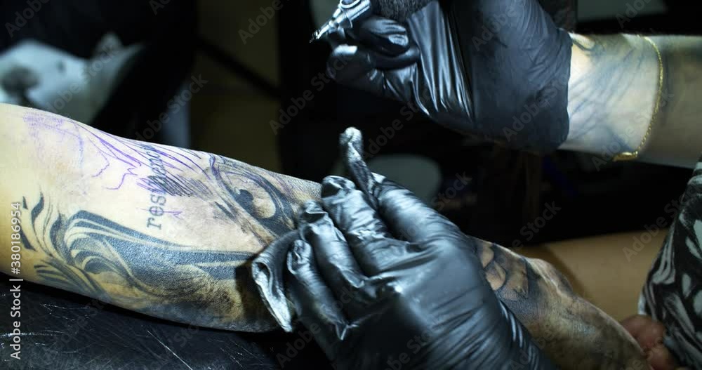 Tattooist draws a pattern on clients arm Tattooist draws a pattern on clients arm