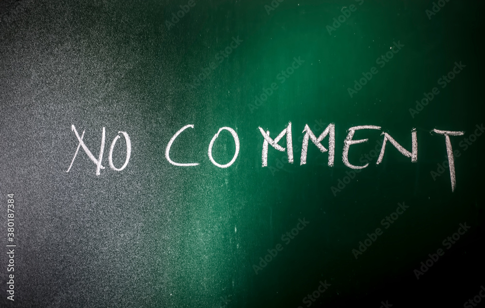 Fototapeta premium No Comment wrote on green board with chalk, a horizontal shot of No comment written on the blackboard.