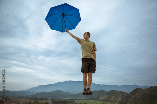 A man is floating in mid-air with an umbrella photo