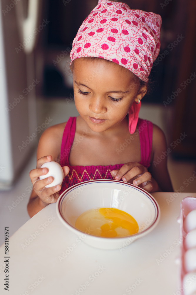 Yong girl cracking eggs into a bowl Yong girl cracking eggs into a bowl