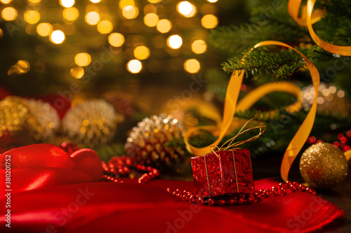 Xmas banner with christmas decorations: cone, balls, tape, beads, gift box and Christmas tree on garland bokeh background. Copyspace. New year congratulations card